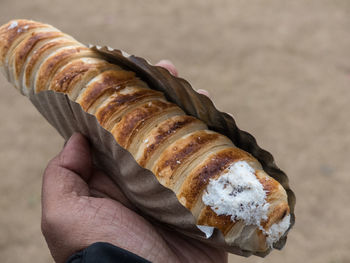 Cropped hand holding sweet food outdoors