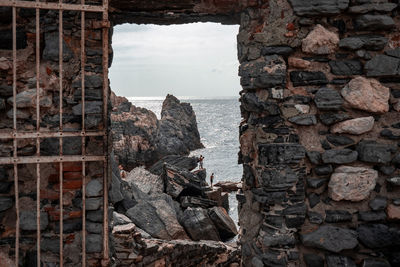 Stone wall window overlooking scenic landscape of ligurian sea and rocky cliff in portovenere, italy