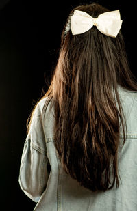 Rear view of woman against black background