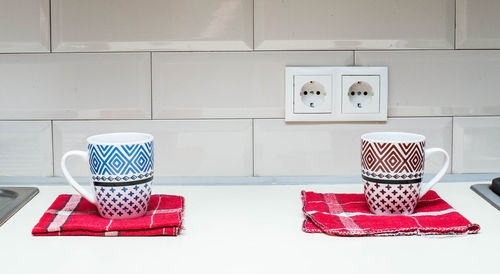 Coffee cup on table against white wall