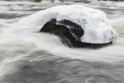 Ice on stone in winter river