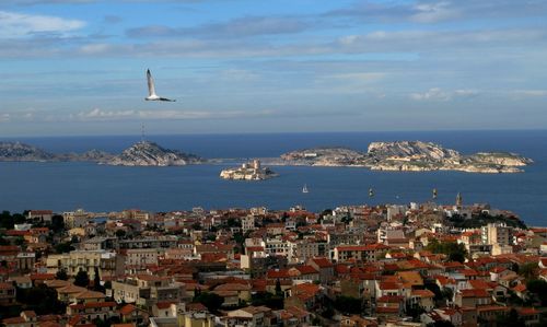 High angle view of townscape by sea against sky