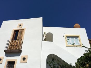 Low angle view of buildings against clear blue sky