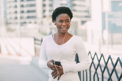 Attractive african girl talking on the phone in the city using headphones. online communication