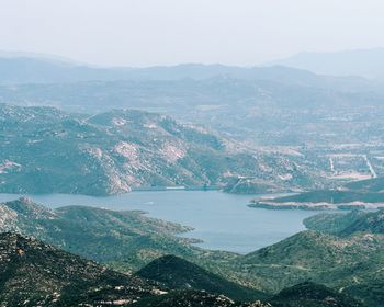 Aerial view of city by sea against sky