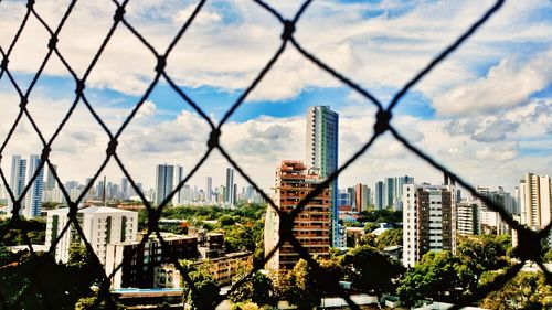 View of cityscape against cloudy sky