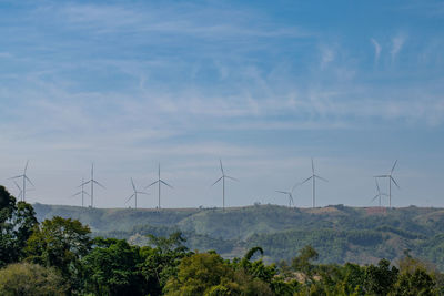 Wind turbines on land against sky