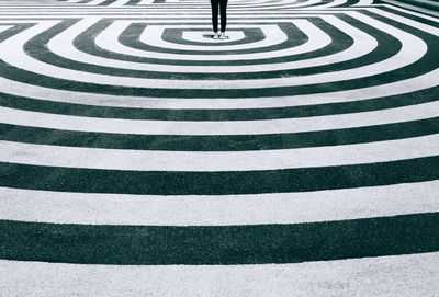 Crop unrecognizable person standing in center of 3d hypnotic spiral ground in city of hamburg person