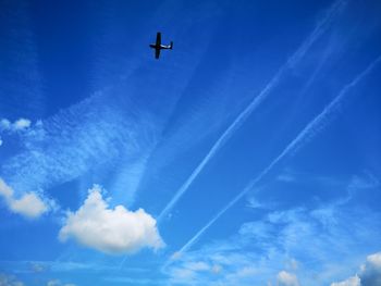 Low angle view of airplane flying against blue sky