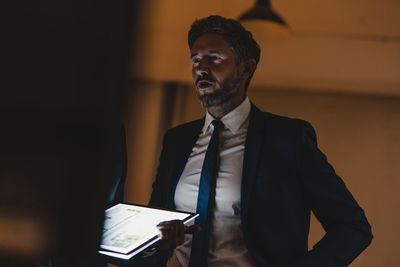 Two businesssmen with shining tablet talking in office