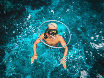 High angle view of shirtless man swimming in sea