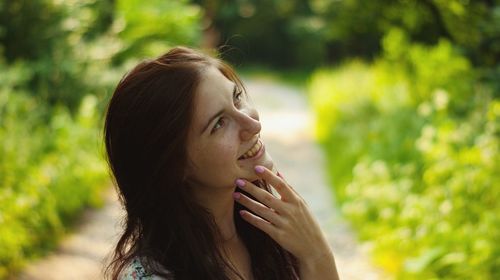 Portrait of smiling young woman looking away outdoors