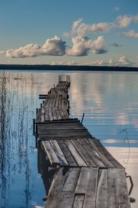 Wooden pier over lake against sky