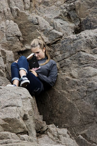 Young woman lying on rock