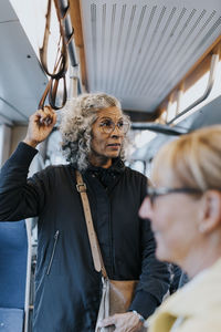 Contemplative female entrepreneur looking away while commuting through bus