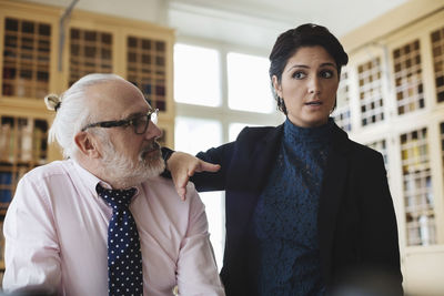 Confident female lawyer discussing with senior coworker in library