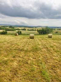 Hay bales on field against sky