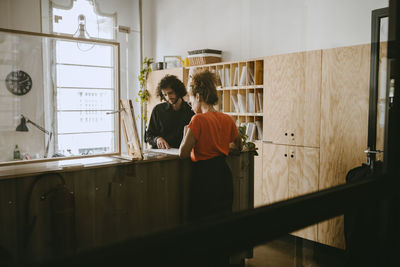 Male entrepreneur discussing with female colleague over document at office