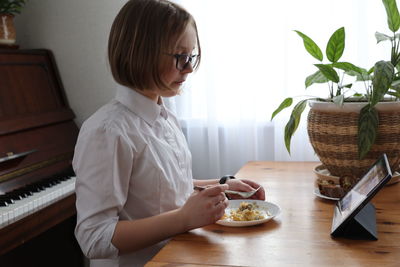 Woman sitting on table at home