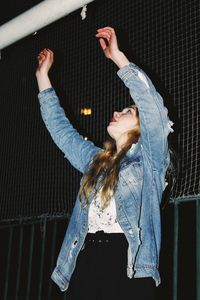 Full length of woman standing against wall