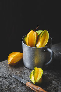 Close-up of fruits on table against black background