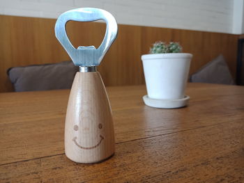 Close-up of bottle opener on wooden table in restaurant