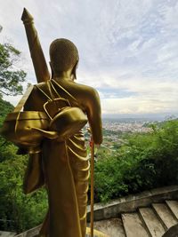 Sculpture of buddha statue against trees