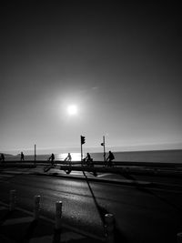 Vehicles on road against sky during sunset