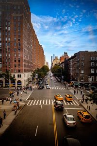 Cars on road in city against sky