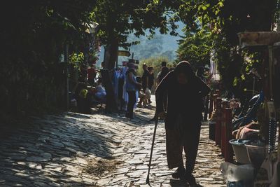 Rear view of men walking on street in city