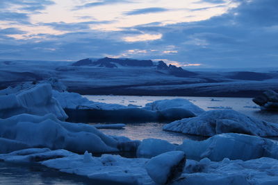 Scenic view of frozen lake against sky during sunset