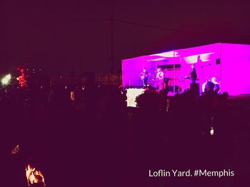 Crowd at music concert in city at night