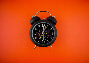 Close-up of clock against orange background