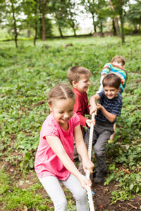 Siblings standing on land against trees