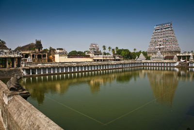 Reflection of building in water against clear blue sky