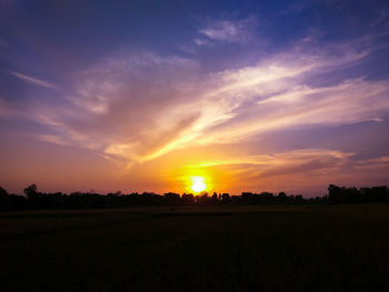 Scenic view of silhouette field against sky during sunset