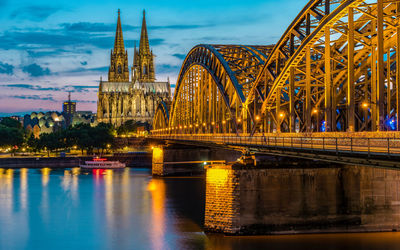 Illuminated bridge over river at night