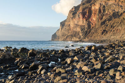 Rocks on beach against sky