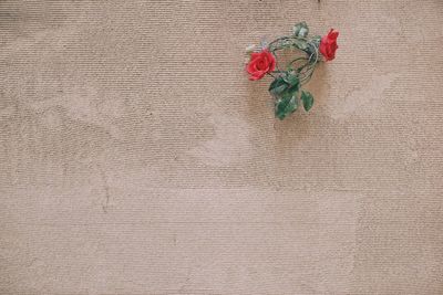 Red artificial flowers on wall