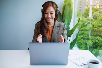 Portrait of young woman using laptop on table