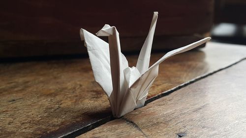 Paper crane on wooden table