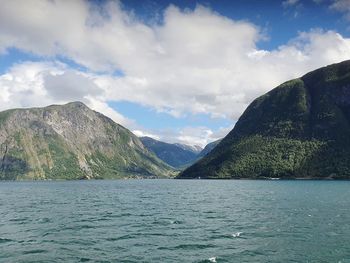 Scenic view of lake by mountains against sky