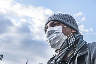 Low angle view of man wearing hat against sky