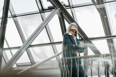 Woman with long grey hair standing in a loft