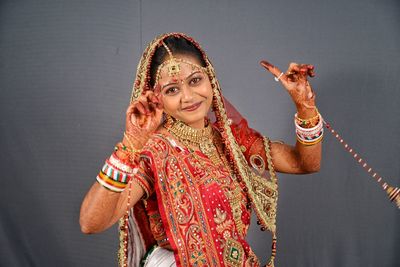 Portrait of smiling bride dancing against gray backdrop