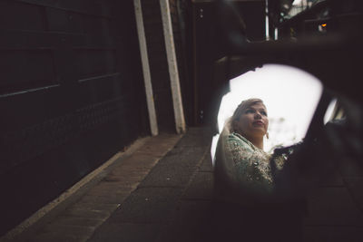 Woman reflecting on side-view mirror of motorcycle