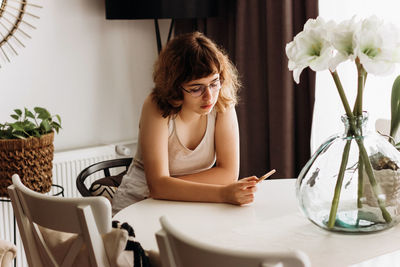 Woman sitting on table at home