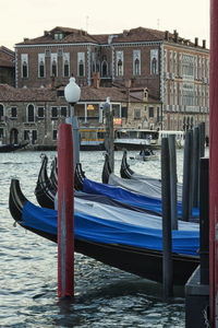 Boats moored on wooden post in water