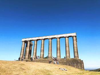 Ruins of historical building against clear blue sky