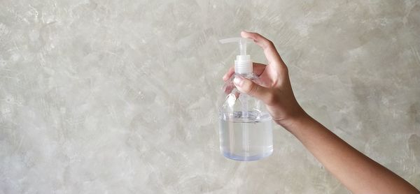 Midsection of woman holding glass bottle